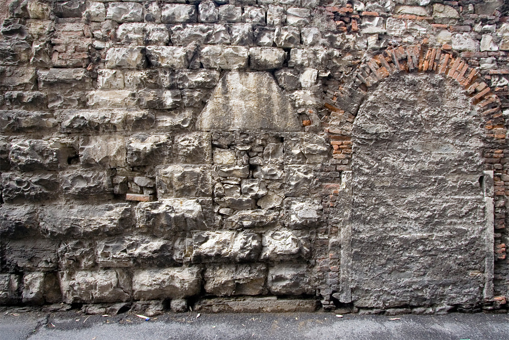 Muro di giardino in vicolo delle Galline. Si nota la parete in bugnato e una finestra con un grosso architrave monolitico (XI Sec.).